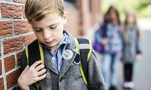 Kind op het schoolplein bij de gevel van de school